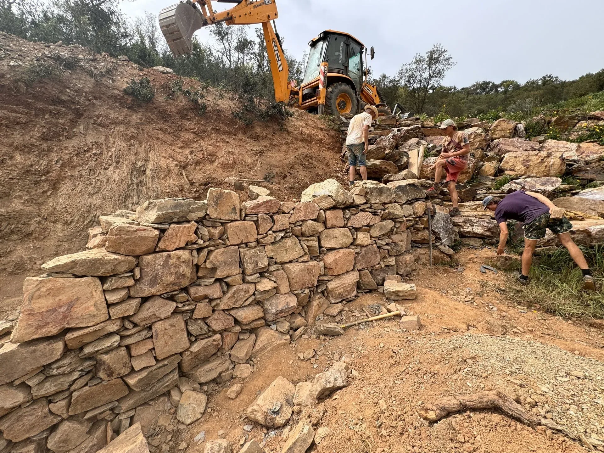 Builders coursing stone into a new retaining wall
