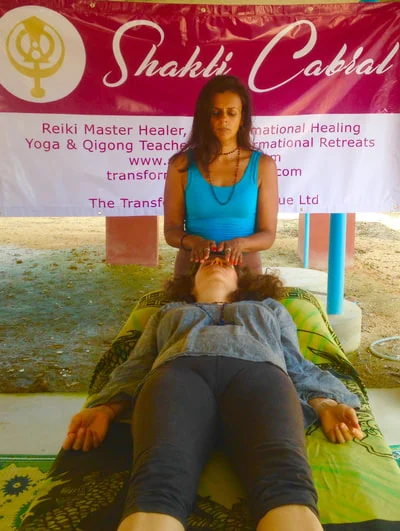 Shakti Cabral standing at the head of a person lying on a mat during a session